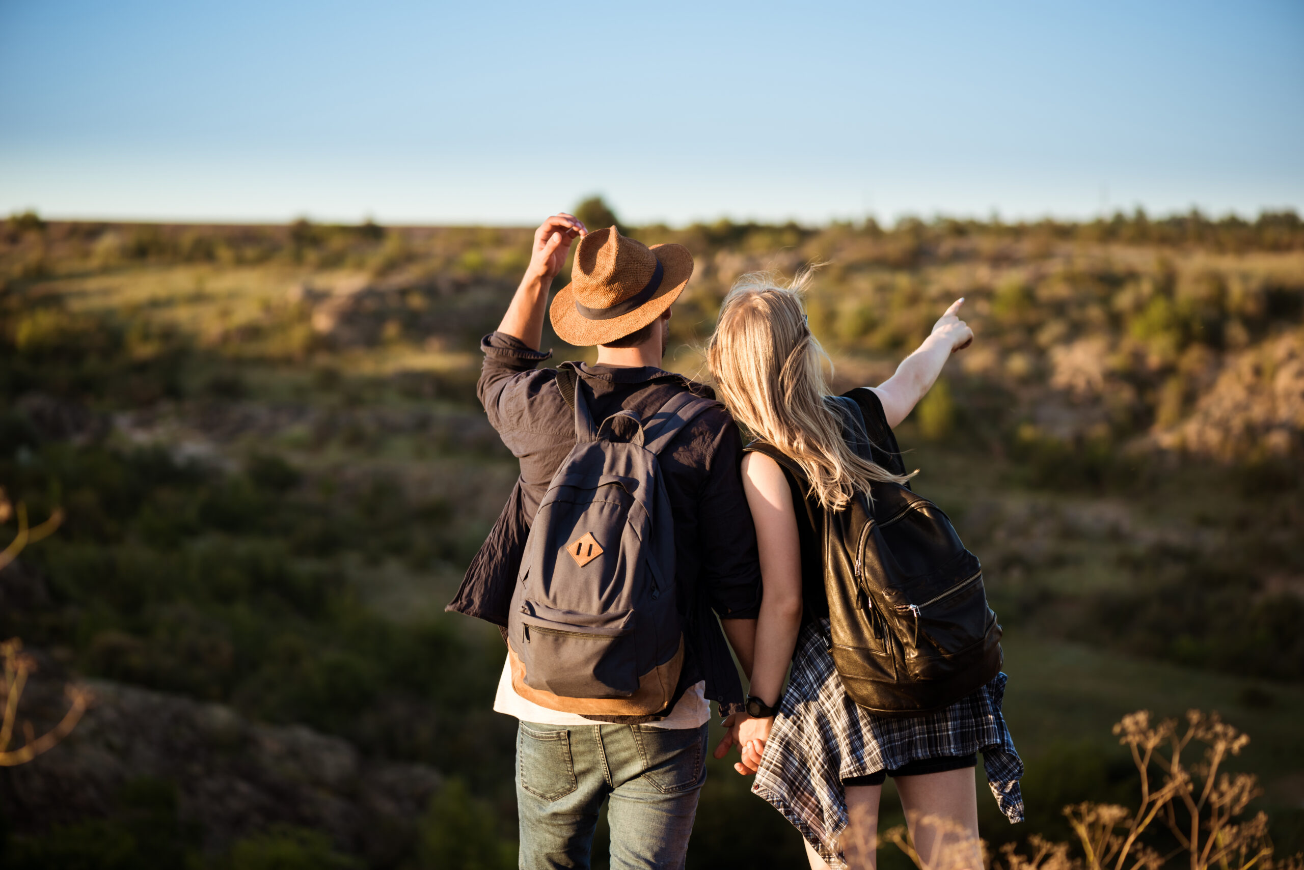 Young beautiful couple resting, enjoying view in canyon. Copy space.